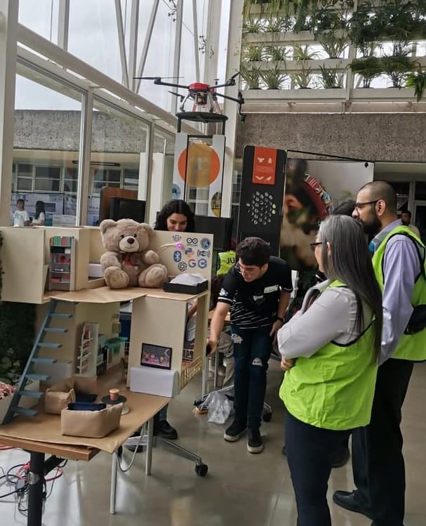 Estudiantes muestran un proyecto a visitantes